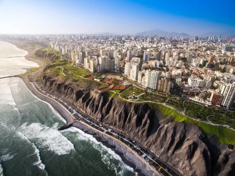 Lima vista desde el aire, con la ciudad, el malecón y el mar.